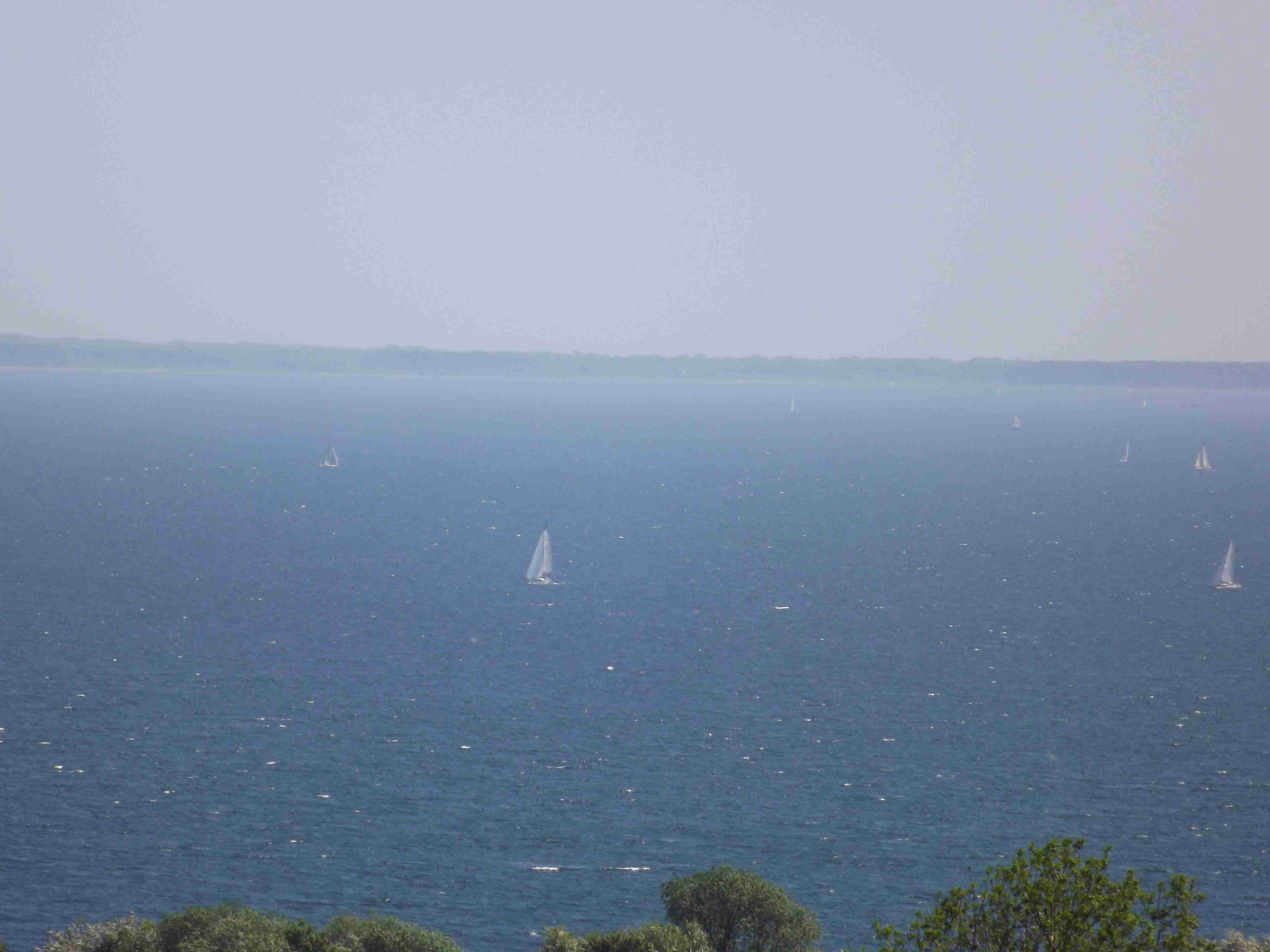 Foto: Die blaue Ostsee glitzert im Sonnenschein. Darin kleine Boote mit weißen Segeln. Quelle: S.Hahn